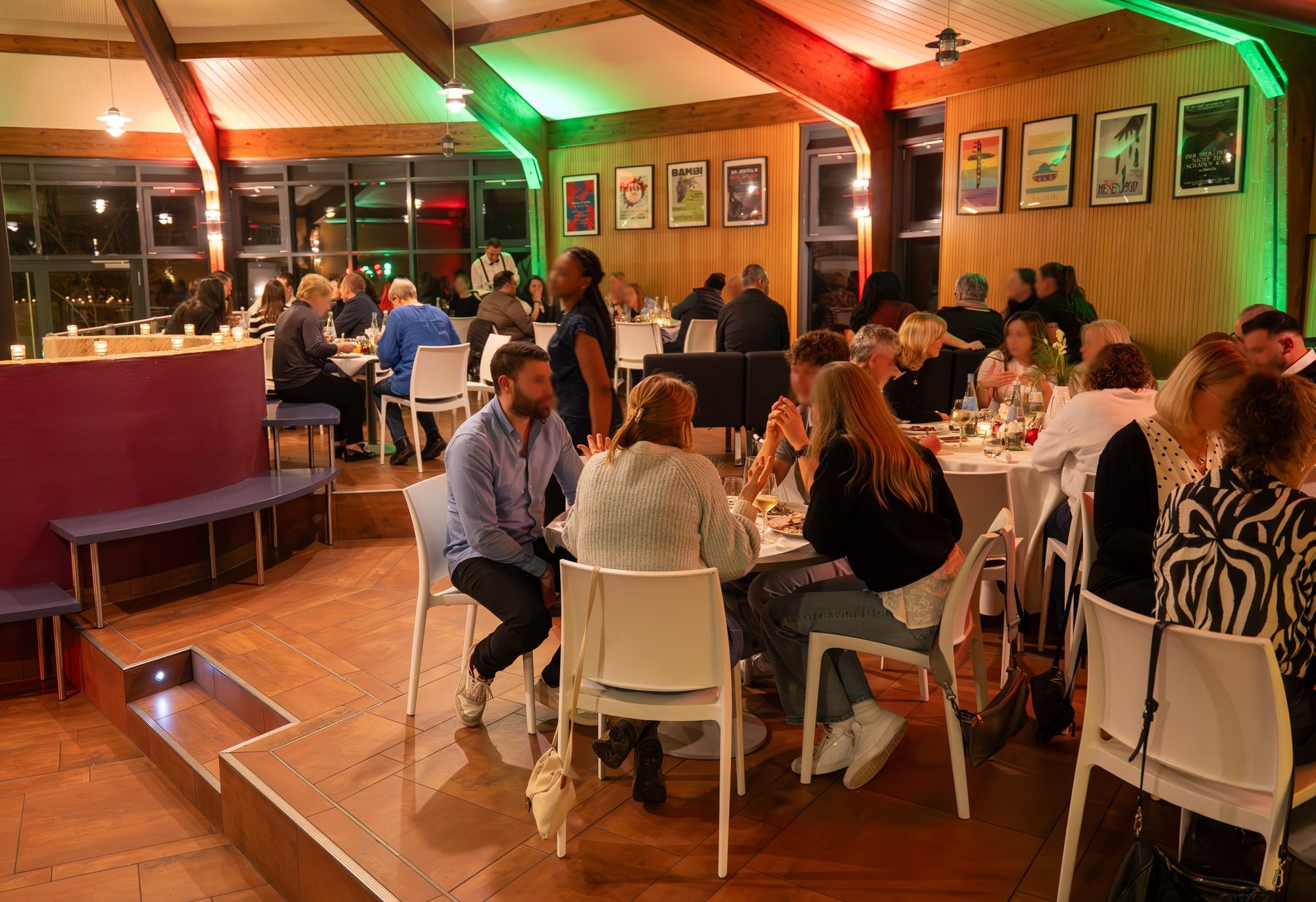 Gäste an runden Tischen mit weißen Stühlen bei einer Abendveranstaltung in der Rotunde in Bonn Bad Godesberg