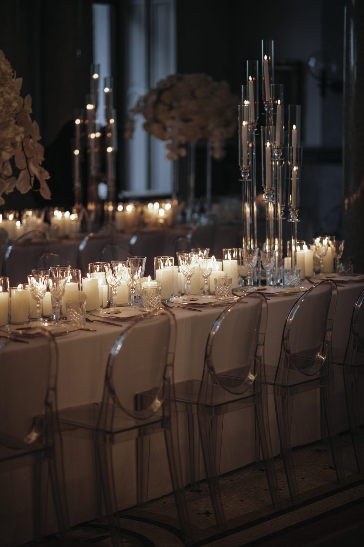 Hochzeitstafel bei Kerzenlicht mit Kristallgläsern und transparenten Stühlen in der Stella Rheni