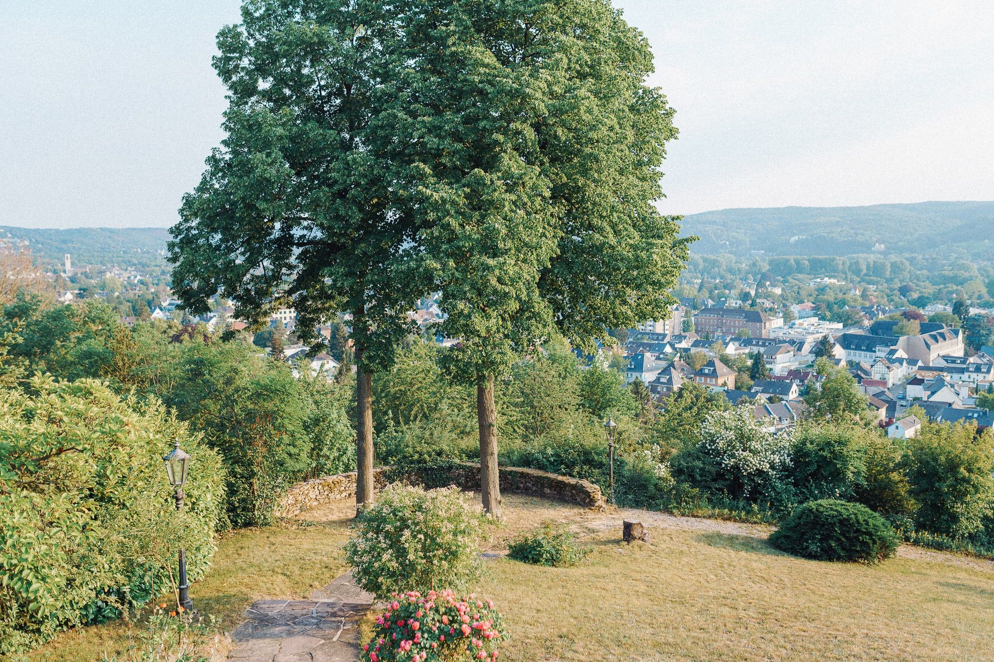 Garten der Villa Heckenfels am Hang mit alten Bäumen und Blick hinunter auf Bad Honnef und die Hügel des Rheintals