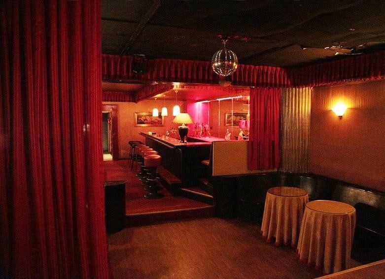 Tanzbereich im Untergeschoss der Kokett Bar mit Discokugel, Stehtischen mit goldenen Hussen und Blick zur Bar