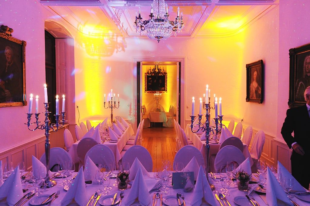 Festlich beleuchteter Saal auf Schloss Wachendorf mit Kerzenleuchtern, Kristalllüster und langen Tafeln am Abend